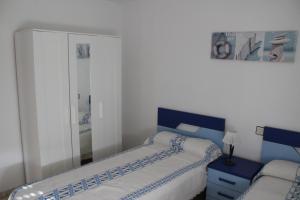 トレモリノスにあるApartamento Carihuela Beach & Sunのベッドルーム1室(ベッド2台、鏡付)