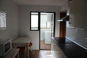 a kitchen with a counter top and a table and a refrigerator at Apartamento Carihuela Beach & Sun in Torremolinos