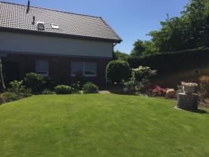 ein Haus mit einem Garten mit grünem Rasen in der Unterkunft Apartment am Park in Tönisvorst