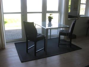uma mesa de jantar com duas cadeiras e um vaso sobre ela em Ved Vandet em Skanderborg