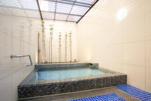 a swimming pool in a white tiled bathroom at Kuretake Inn Premium Fujinomiya in Fujinomiya