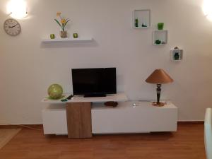 a living room with a tv on a white desk at Apartment Lju on the Beach in Split