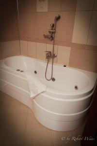 a bath tub in a bathroom with a faucet at Pensiunea Vlahia Inn in Moieciu de Sus +16 photos