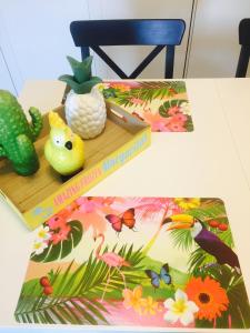 a table with a book and a pineapple and a cactus at Vakantiestudio Melroce in Bredene