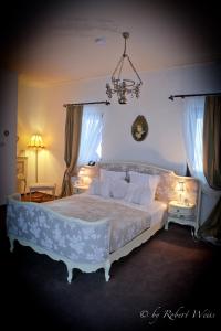 um quarto com uma cama grande e um lustre em Pensiunea Vlahia Inn em Moieciu de Sus