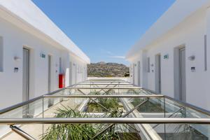 a glass walkway in a building with plants at Rodos Star Hotel in Afantou