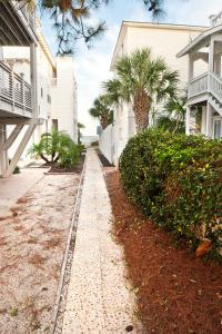 a sidewalk in front of a house with palm trees at DeSoto Beach Bed and Breakfast in Tybee Island