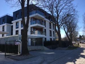 a white building with a tree in front of it at Bursztynowa 23 in Jelitkowo