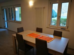 Appartamento Chiara في ليدرو: غرفة طعام مع طاولة وكراسي خشبية