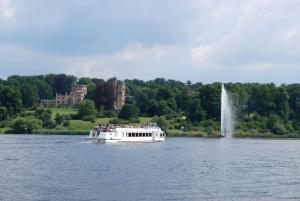 a boat on the water with a fountain in the background at Ferienwohnung Babelsberg in Potsdam