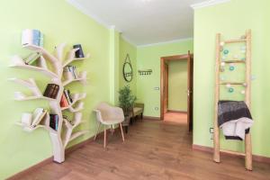 um quarto com paredes verdes e uma estante de livros em Stylish Apartment em Villajoyosa
