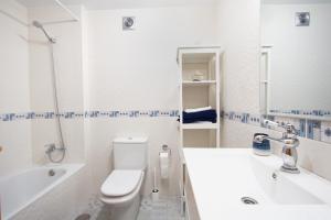 a white bathroom with a toilet and a sink at Stylish Apartment in Villajoyosa +19 photos