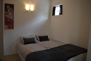 um quarto com uma cama com duas almofadas em Kućica [kȕtɕitsa] - small house with free parking em Zagreb