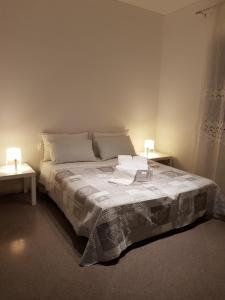 a bedroom with a bed with two tables and two lamps at Holiday B&B 1984 in Bari