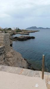 Una vista del océano con rocas en el agua. en Stella Maris, en Favignana