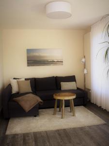 a living room with a black couch and a table at Die Stadtwohnung in Stadthagen