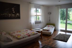 Zimmer mit 2 Betten, einem Tisch und Fenstern in der Unterkunft Ferienwohnung im Dettenbachtal in Waldkirch