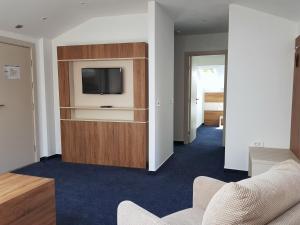 a living room with a tv on a entertainment center at Boutique Hotel Mali Raj in Opatija