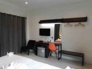 una camera da letto con scrivania, computer e 2 sedie di Limelight Village a Thong Nai Pan Yai