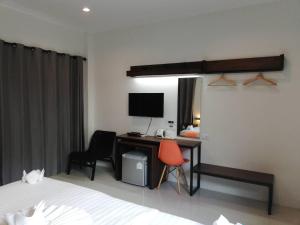 a bedroom with a desk with a computer and two chairs at Limelight Village in Thong Nai Pan Yai