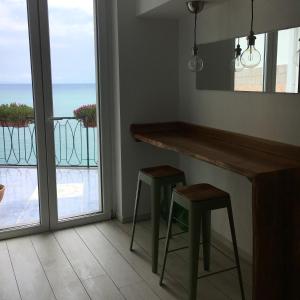 cocina con barra con 2 taburetes y balcón en Chez-Lu Ravello, en Ravello