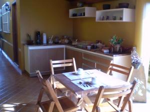 a dining room with a table and chairs and a kitchen at Hotel da Gaúcha in Tucuma