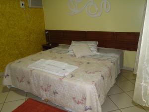 a bed with towels on it in a room at Hotel da Gaúcha in Tucuma