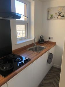 a kitchen with a stove and a sink and a window at The Old Albion at Plover Cottage Lindley in Huddersfield