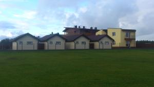 a group of houses in a field with a building at Aringos Rezidencija in Šventoji