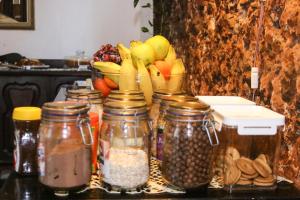 a group of jars filled with food and a bowl of fruit at Pousada Portas da Amazônia in São Luís