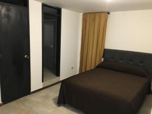 Schlafzimmer mit einem Bett und einem Spiegel in der Unterkunft Apartaestudio San Nicolas in Popayan