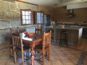 a kitchen with a wooden table and chairs at O Candil De Santa Ana in Pontevedra