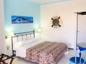 a bedroom with a bed and a clock on the wall at Il Mediterraneo - Adults Only in Ponza