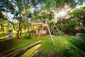 a playground in a park with a swing at Cabanas Parque Suíço in São Francisco de Paula