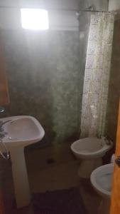 y baño con lavabo y aseo. en Departamentos Calamuchita en Santa Rosa de Calamuchita