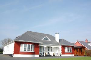 a red house with a gray roof at Hazelbrook Killarney in Killarney