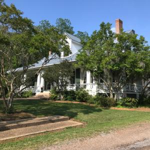 Westside的住宿－Canemount Plantation Inn，前面有树木的白色房子