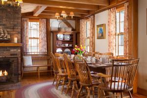 a dining room with a table and chairs and a fireplace at Seven Sea Street Inn in Nantucket