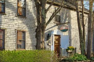 a white house with a tree in front of it at Seven Sea Street Inn in Nantucket