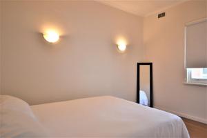 a bedroom with a bed and two lights on the wall at Breakers 4 2 Hill Street in Port Macquarie