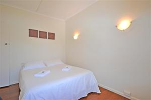 a bedroom with a white bed with two towels on it at Breakers 4 2 Hill Street in Port Macquarie
