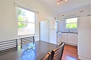 a kitchen with a table and a refrigerator at Breakers 5 2 Hill Street in Port Macquarie