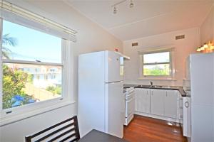 a kitchen with a white refrigerator and a window at Breakers 6 2 Hill Street in Port Macquarie