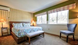 Hotel Charlotte في غروفلاند: غرفة نوم بسرير وكرسي ونافذة