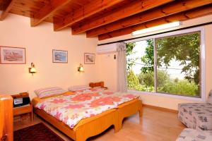 a bedroom with a bed and a large window at Eretz Hagalil - Land of Galilee in Amirim