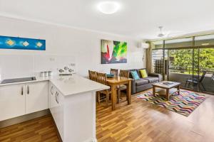a kitchen and living room with a couch and a table at Cascade Gardens in Cairns