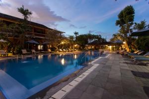 een zwembad in het resort 's nachts bij Bumi Ayu Bungalow Sanur in Sanur