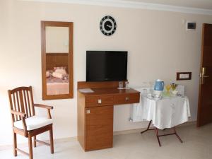 a room with a television and a table with a chair at Ucem Hotel Golden Sea in Altınoluk