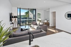a living room with two couches and a table at Anchorage Apartments Hampton in Melbourne