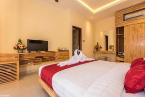 a bedroom with a large bed and a flat screen tv at Bliss Ubud Abangan in Ubud